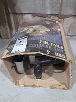Worn cardboard box with saw partially visible