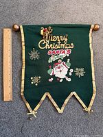 Full view of green felt Christmas banner with ruler for scale