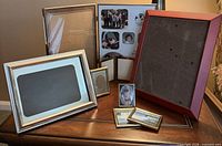 Group shot of eight assorted picture frames displaying variety of sizes, finishes and orientations