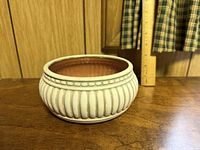 Overall view of ceramic planter showing exterior color, fluted design, and terracotta interior