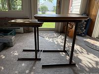 Side view of both nesting tables showing size difference, black metal bases