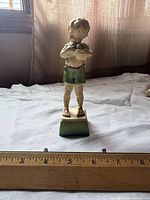Front view of Royal Doulton porcelain figurine showing full figure and ruler for scale