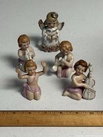 Group shot of all five figurines with ruler for scale