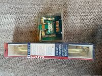 Packaged Weiser knob set and packaged Safety 1st grab bar on carpeted floor