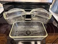 Rectangular baking dish, loaf pan and lid displayed on stovetop