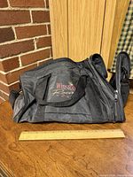 Overall view of Winston Racing Team black nylon duffel bag with ruler for scale