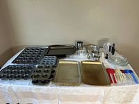 Full lot view of assorted bakeware and utensils on table