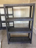 Front view of entire 4-tier black plastic shelving unit