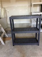 Front view of black plastic 3-tier shelf