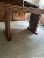 table leg detail showing wood grain and pedestal base