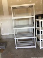Front view of wide four-tier white plastic shelf