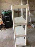 Front angled view of white plastic four-tier shelving unit