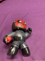 Front view of Darth Maul style vinyl figure showing facial design and lightsaber