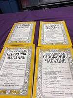 Four National Geographic magazines laid out showing covers and yellow borders
