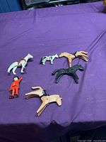 All seven Playmobil pieces laid out on purple cloth