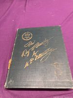 Front cover of dark green cloth-bound book with gilt title and theosophy emblem