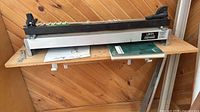 Full view of Leigh D4 jig on shelf with manuals beneath