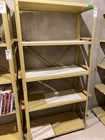Front view of yellow metal shelving unit with five shelves