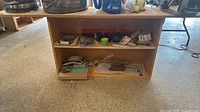 Front view of plywood bench showing two shelves and contents (contents excluded from sale)
