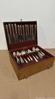 Chest open showing knives in upper rack and assorted flatware in lower drawer