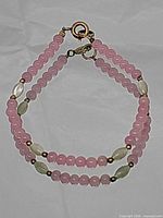 Full view of double-strand pink beaded bracelet showing clasp and bead arrangement