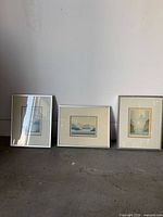 All three framed prints leaning against wall