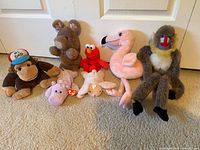 Group shot of seven plush animals lined up on carpet