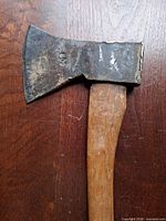 Close view of hatchet head showing stamp 800 and wood handle connection