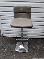 Front view of bar stool showing seat, backrest, chrome pedestal and base