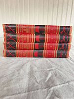 Stack of four volumes showing spine titles and decorative tooling