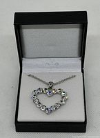 Necklace displayed in open box showing heart pendant with cubic zirconia stones