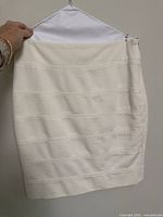 Front view of cream pencil skirt on hanger