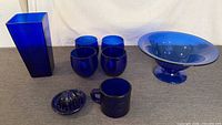 Group shot showing vase, four cups, reamer with cup, pedestal bowl