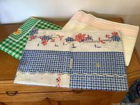 Three folded tablecloths showing patterns and colors