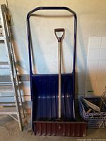 Snow scoop pusher and shovel leaning together