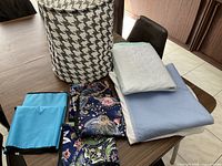 All items grouped on table: hamper, five bibs, two mattress pads