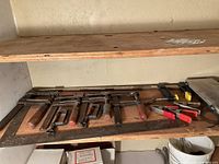 Shelf with six F-style bar clamps, framing square, other tools