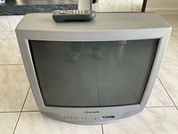 Front view of Panasonic CRT television with remote on top