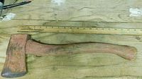 Full view of axe on tabletop with ruler showing length