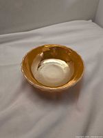 Top view showing iridescent amber interior and scalloped rim
