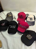Seven caps laid out showing front logos