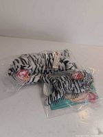 Full-size Blizzard plush in bag beside sealed Teenie Beanie bag