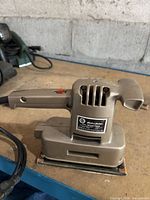 Left side view showing model label, ventilation slots, handle and power cord