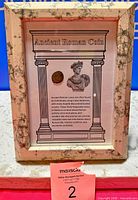 Front view of framed bronze Roman coin display