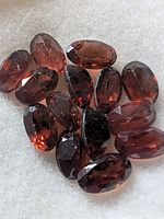 Group of oval faceted garnets on white background