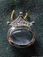 Front view showing oval cabochon blue topaz, crown motif, gold-tone bail
