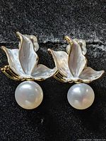Front view of earrings showing enamel petals and pearls