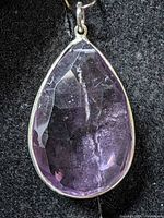 Front view of pear-shape amethyst pendant in silver bezel