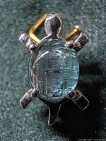 Front view of silver turtle pendant with blue topaz stone