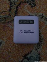 Front of lavender power bank showing Amara & Associates logo and LED indicator window